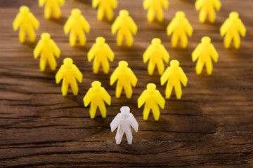 Elevated View Of White Figure Leading Yellow Human Figures