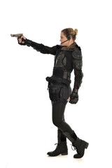 full length portrait of female  soldier wearing black  tactical armour, holding a gun, isolated on white studio background.