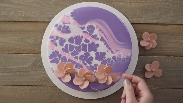 Step by step. Pastre shef decorating mousse cake with purple mirror glaze with chocolate pink flowers