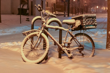 Fototapeta na wymiar Snow covered bike with a milk crate basket in downtown Ann Arbor, Michigan