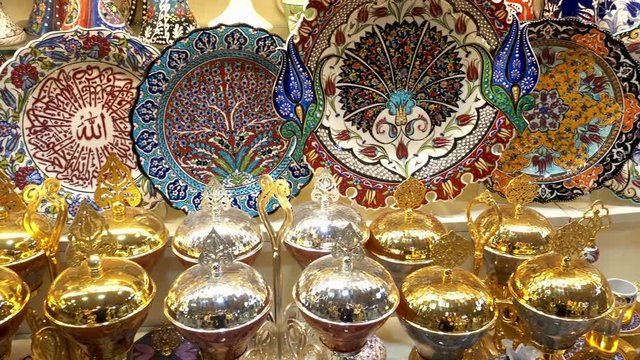 4K view of Turkish souvenir shop. Traditional colorful plates and metal utensils at the Grand Bazaar. Istanbul, Turkey.