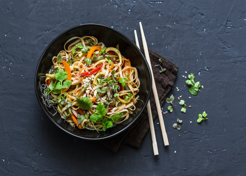 Pad Thai vegetarian vegetables udon noodles in a dark background, top view. Vegetarian food in asian style. Copy space