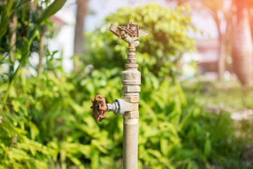 faucet and nature background. subject is blurred.