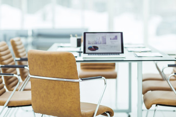  open laptop computer with financial charts on the table with the Manager in a modern office.