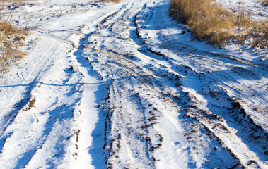 Fototapeta na wymiar Footprints from a car in the snow