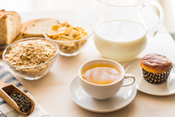 Obraz na płótnie Canvas Useful rustic breakfast on the table - tea, oatmeal, milk and fresh cake - healthy eating concept