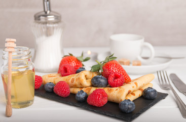pancakes with fresh fruits, strawberry, raspberry, honey and coffee