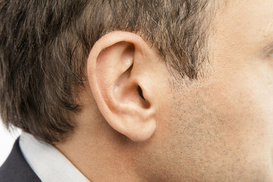 D&eacute;tail de l'oreille d'un homme aux cheveux ch&acirc;tains 