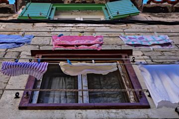 Typical Dalmatian/ Mediterranean scene of Colorful clothes laundry drying outdoor under sun and open sky in line