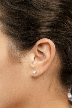 Oreille d'une femme en gros plan avec une boucle d'oreille