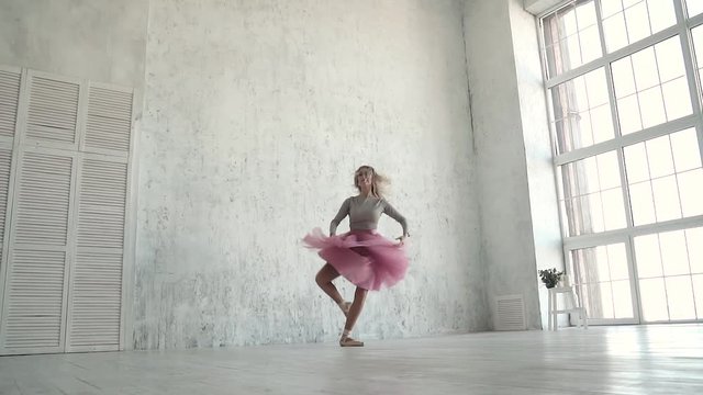 Ballerina performing pirouettes in studio. ballet dancer in a classic tutu and pointe