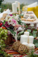  Picnic wicker basket with fresh fruit, flowers in the camping nature background.