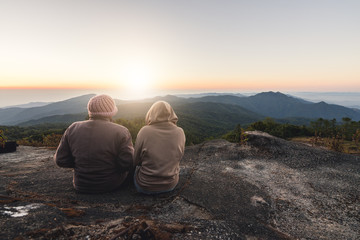 Couple lover sit at the hill wating for sunrise in the morning at Doi Inthanon National Park, the top highest mountain of Thailand