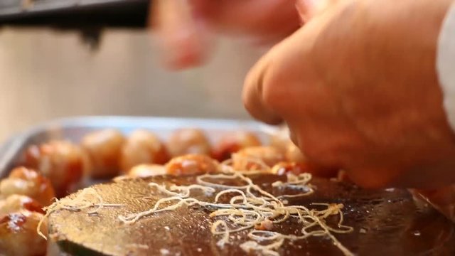 man picking Thai sausages on stove