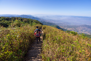 Obraz premium Doi Inthanon National Park, The hill tribe carrying a child walk on the top highest mountain of Thailand