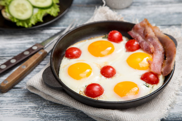 breakfast with eggs, cherry tomatoes, bacon and fresh toasted toast