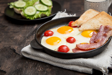 breakfast with eggs, cherry tomatoes, bacon and fresh toasted toast