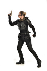 full length portrait of female  soldier wearing black  tactical armour, holding a gun, isolated on white studio background.