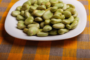 fresh broad beans on a rustic background