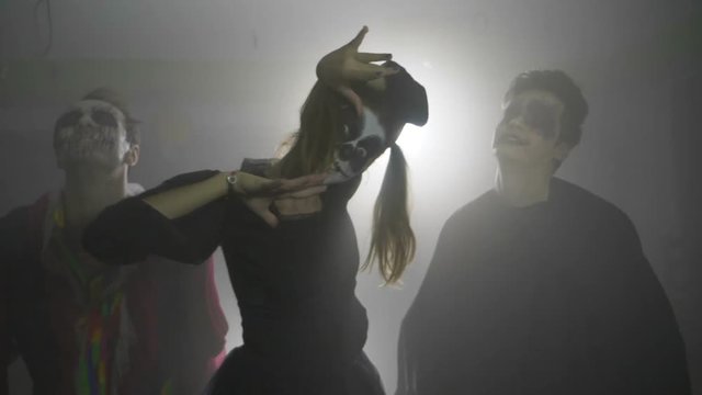 Halloween vampire joker and horror doll scaring the viewer and laughing crazy in slow motion party