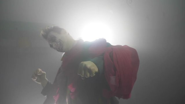 Infernal evil halloween joker clown with a spooky costume laughing crazy in slow motion