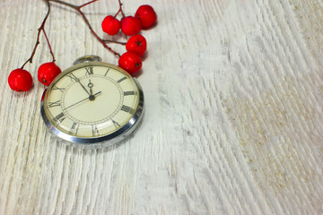composition, red berry retro clock on a white wooden table. Christmas background.