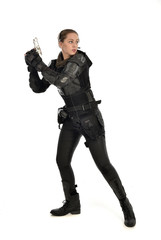 Fototapeta premium full length portrait of female soldier wearing black tactical armour, holding a gun, isolated on white studio background.