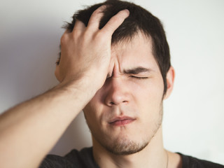 Fototapeta premium young man holding onto his head. Headache