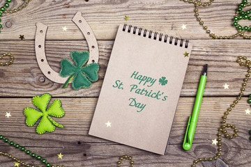 St.Patrick's day greeting message with horseshoe and felt clover leaves on wooden boards