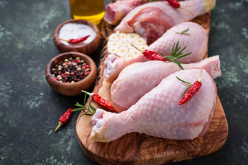 Raw chicken legs with spices and garlic.