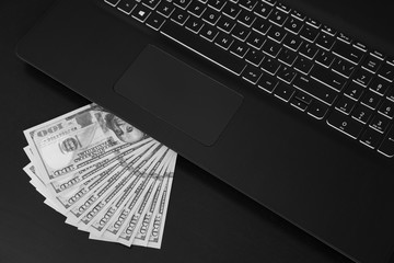 Laptop and US dollar money, Computer notebook and dollar banknotes. Technology with US dollar bank note. black and white.