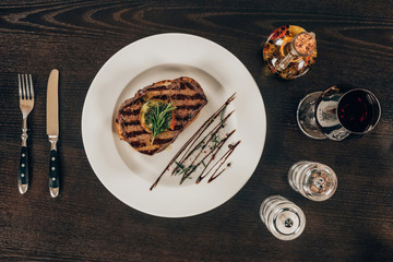 top view of beef steak on plate on wooden table