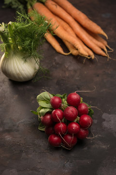Rustic set of radishes along with other vegetables on a table. I