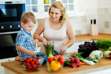 Pregnant woman preparing meal with son