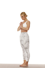 Yoga, sport, training and lifestyle concept.  Portrait of young beautiful woman in white sportswear on white background.