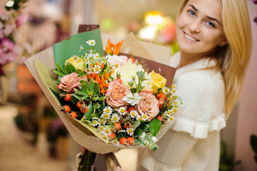 Young smiling blonde woman with a large valentine bouquet