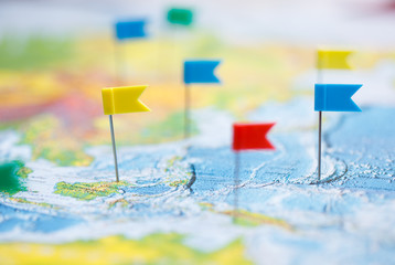 Macro photo with flag pushpins and world map.Travel concept