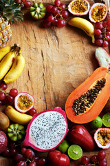 Tropical fruits frame with copy space. Smoothie or juice ingredients on wooden table. 
