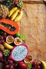 Top view of assorted exotic fruits on wooden table with copy space. Tropical smoothie  and juice ingredients.