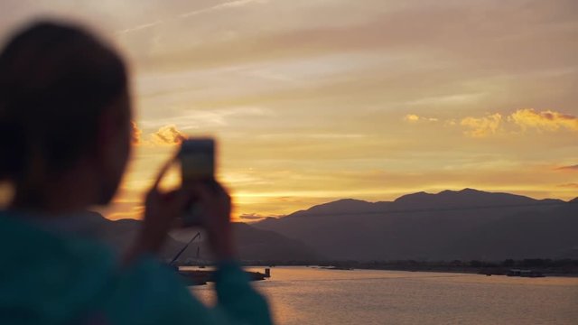 Defocus hands make photo of mountains at sunset on smartphone rapid slow motion