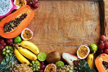 Top view of assorted tropical fruits on wooden table with copy space.