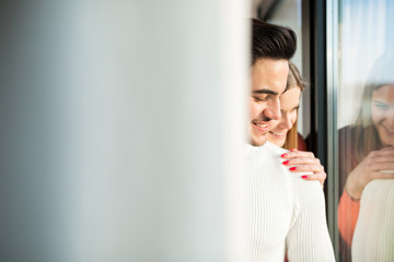 Obraz premium Happy couple standing together near the window