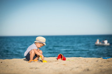 Little caucasian boy is playing at beach
