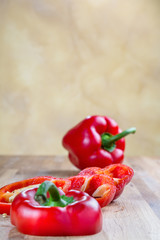 fresh red bell pepper lying on the oak chopping Board