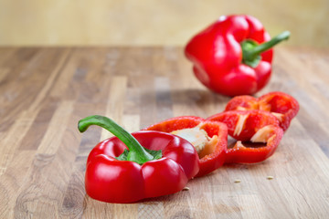 fresh red bell pepper lying on the oak chopping Board