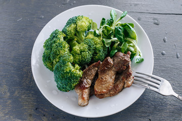 Broccoli, lettuce corn and meat in a plate