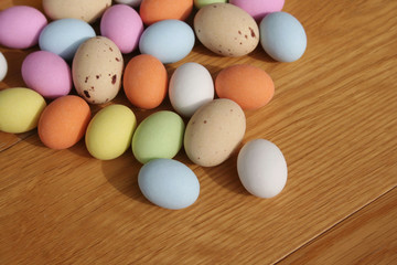 Multicolored chocolate Easter eggs on wooden table. Easter background
