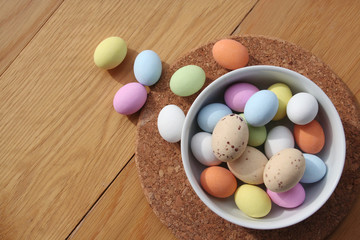 Multicolored chocolate Easter eggs on wooden table. Easter background
