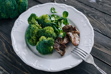 Broccoli, lettuce corn and meat in a plate