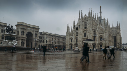 Obraz premium Tourists and locals at Piazza del Duomo in Milan, Lombardy, Italy with the Galleria Vittorio Emanuele II, and Duomo church cathedral